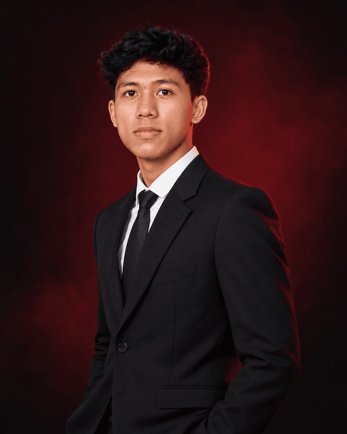 Adlan Fakhruzzaman in a confident three-quarter pose wearing a black suit